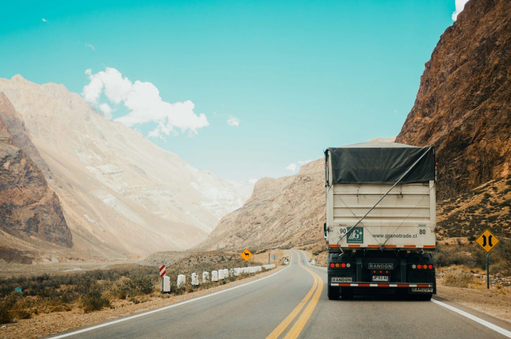 Camion blanc et noir près d'une montagne en journée