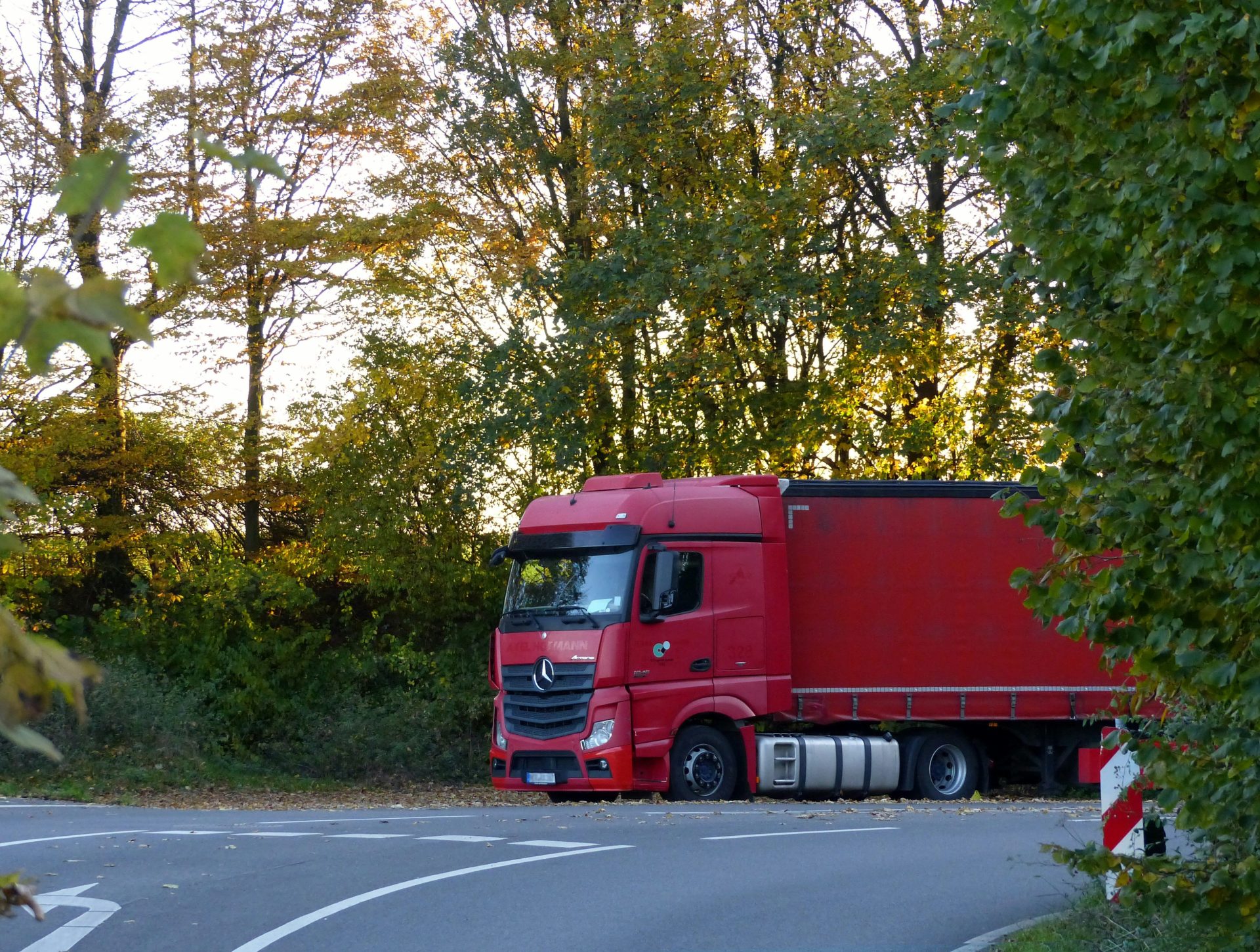 Un camion rouge est garé sur le bord de la route.